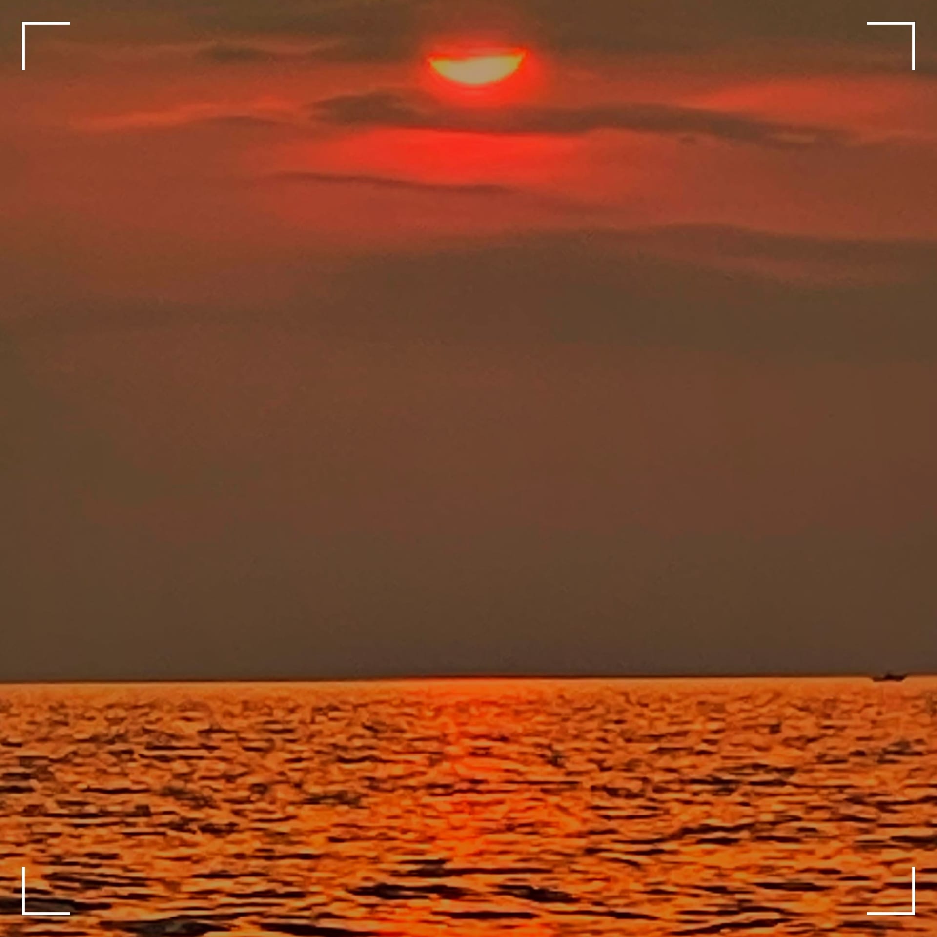 The sun is cutting through cirrus clouds 20 minutes before sunset over Lake Michigan, near Luddington, MI.